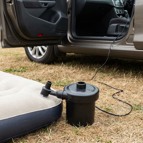 Air pump inflating a camping airbed with its power cable running into the car