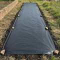 Black mulch sheet covering a garden bed