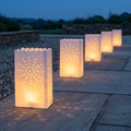 Lantern bags illuminating a garden path at dusk
