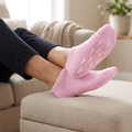 Pink moisturising socks worn while relaxing at home