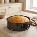 Springform cake pan containing a golden sponge cake in a kitchen