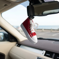 Trainer air freshener viewed at an angle in a different car with a coastal backdrop