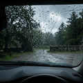 View from inside a car with rain beading and running down the windscreen