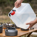Water carrier tilted to fill a camping kettle