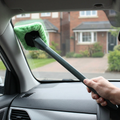 Windscreen cleaning mop in use inside a parked car